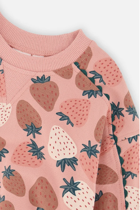 A close-up of a children's long-sleeve top featuring a pink strawberry print. The design includes strawberries in shades of brown, dusty rose, and cream, with dark teal-green leafy tops.