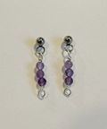 Pair of purple beaded earrings on a light gray background