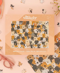Jigsaw puzzle box with dog pattern and 'villager' branding on a pink background.