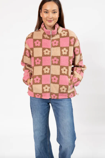 Woman wearing a checkered jacket with pink flowers on a white background