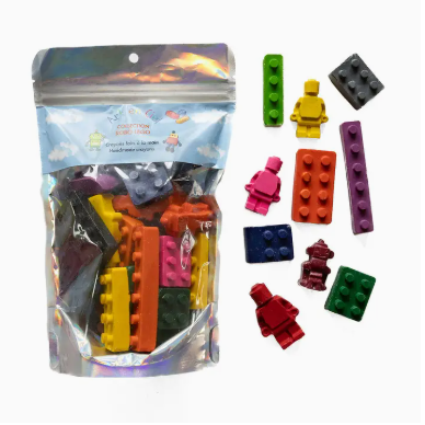 Bag of building blocks and figures with a colorful assortment on a white background