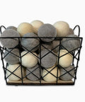 Basket filled with gray and beige balls on a white background