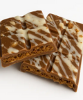 Chocolate bars with a white drizzle on a white background