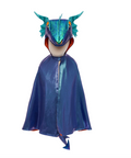 A children's hooded cape costume displayed on a mannequin against a plain white background. The hood features a metallic teal dragon face with horns and eyes, and the cape itself is a shiny dark blue with orange lining visible at the edges.