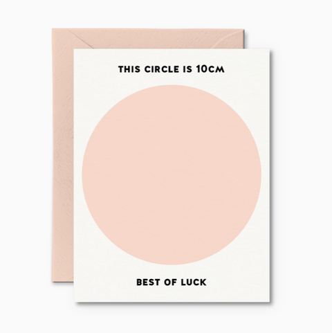 A greeting card with a large pink circle and text 'THIS CIRCLE IS 10cm BEST OF LUCK' on it, accompanied by a pink envelope.