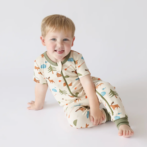 Child wearing a patterned pajama set on a white background