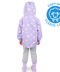 Child wearing a purple raincoat with sheep pattern and gray pants, standing against a white background with Cozy-Dry logo.