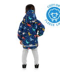 Child wearing a colorful dinosaur-patterned raincoat with a Cozy-Dry fleece-lined label on a white background.