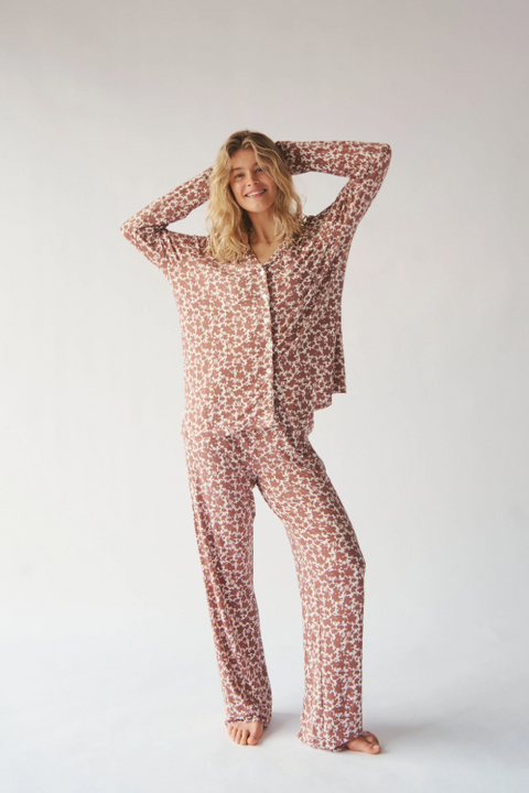 Woman wearing a patterned pajama set on a plain background