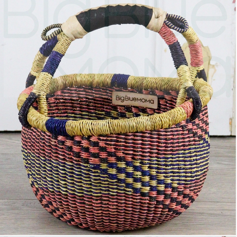 Woven basket with colorful handle on a wooden surface