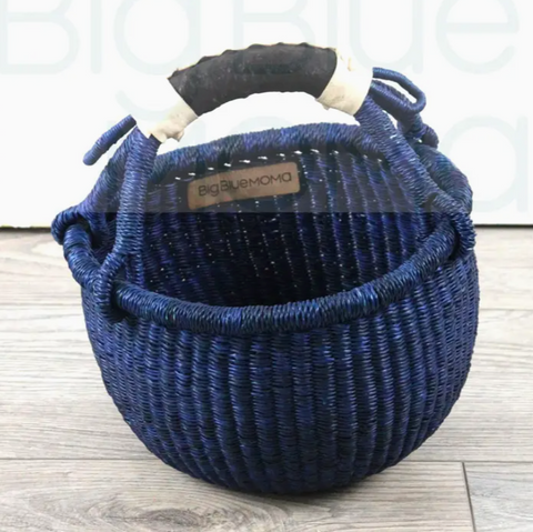 Blue woven basket with handles on a wooden surface