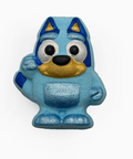 A blue and yellow stylized dog character figurine or charm on a plain white background.