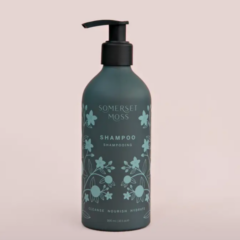 Shampoo bottle with floral design and 'Somerset Moss' branding on a light pink background