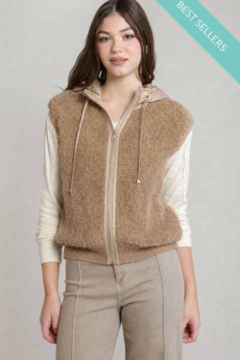 A woman models a brown fuzzy zip-up hooded vest over a cream ribbed long-sleeve top and beige pants against a light gray studio background. A teal 'BEST SELLERS' banner is in the top-right corner.