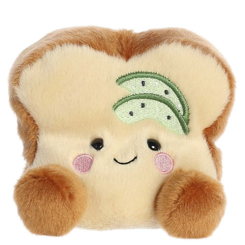 Plush toy resembling a slice of bread with a smiley face and green leaves on a white background