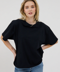 Woman wearing a black oversized sweater and blue jeans on a white background