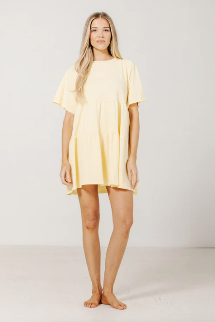 Woman wearing a yellow dress against a white background