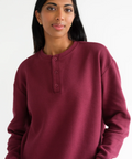 Woman wearing a burgundy long-sleeve shirt on a white background