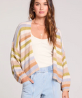 Woman wearing a colorful striped sweater with a plain background