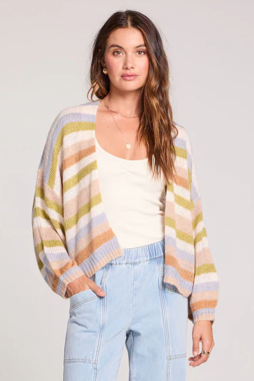 Woman wearing a colorful striped sweater with a plain background