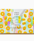 Candy bar packaging with cereal and milk design, featuring colorful stripes and a brand logo.