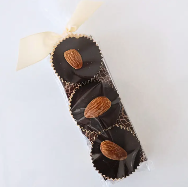 Chocolate bars with almonds in a decorative box on a light background