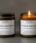 Two candles labeled 'Isle of Rose Citrus Orchard' on a dark background