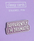 Enamel pin with 'Apparently I'm Dramatic' text on a purple card with 'classy cards' branding.