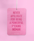 Pink air freshener with text held by a hand against a pink background