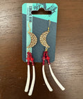 Pair of gold and red earrings on a Coastal Bear Collective card against a wooden background