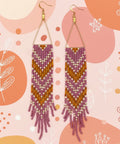 Pair of beaded earrings on a decorative card with a wooden background
