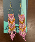 Pair of beaded earrings on a decorative card with a wooden background
