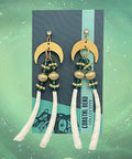 Pair of earrings on a display card with a wooden surface background