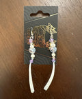Two decorative hairpins on a card with 'Catwalk Collective' branding on a wooden surface.