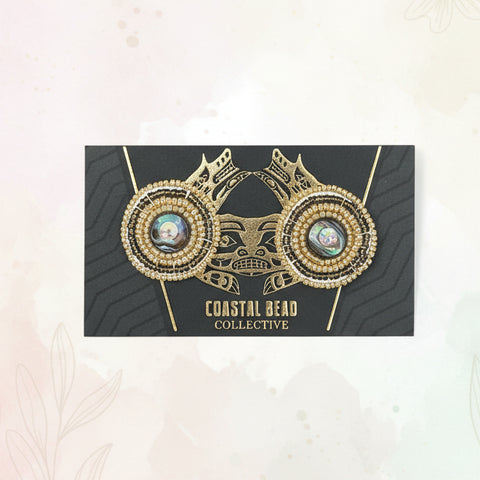 Decorative card with gold and black design on a wooden surface