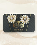 Pair of pearl earrings on a branded card against a wooden surface