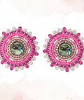 Pair of pink earrings on a card with 'Coast Collection' branding on a wooden surface.