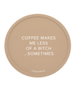 A circular tan sticker or decal with white text that reads 'COFFEE MAKES ME LESS OF A BITCH .