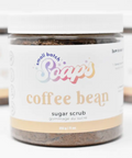 Jar of coffee bean sugar scrub with a visible label on a white background