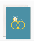 Greeting card with wedding rings design and 'Congrats You Two' text on a blue background