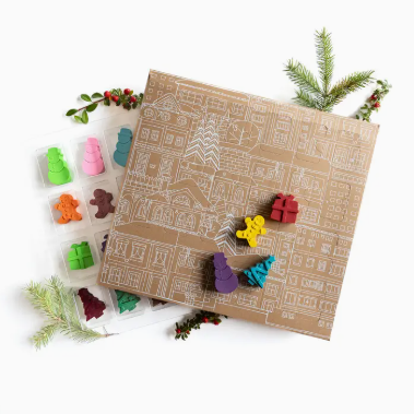 Colorful gingerbread mold set on a decorative paper with Christmas elements.