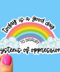 Sticker with rainbow and text 'Today is a good day to disrupt systems of oppression' on a blue background