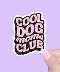 Sticker with 'Cool Dog Moms Club' text held against a purple background