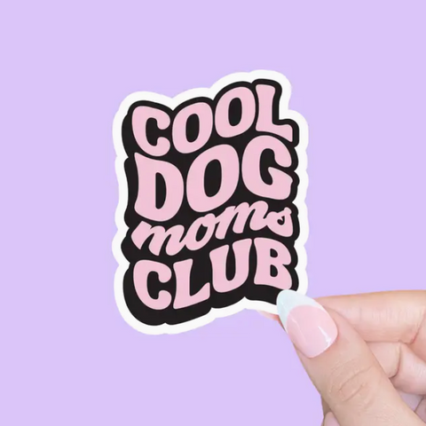 Sticker with 'Cool Dog Moms Club' text held against a purple background