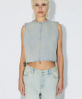 Person wearing a light blue sleeveless denim top and light blue jeans on a white background