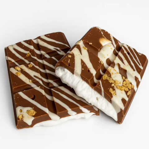 Chocolate bars with white drizzle and gold flakes on a white background