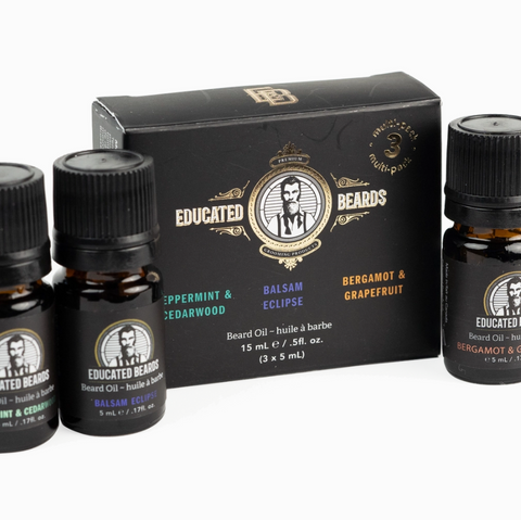 Set of three small bottles with black caps and a branded box on a white background