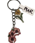 Keychain with floral design and 'MAR' tag on a light gray background
