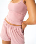 model wearing a soft pink tank top with matching bottoms