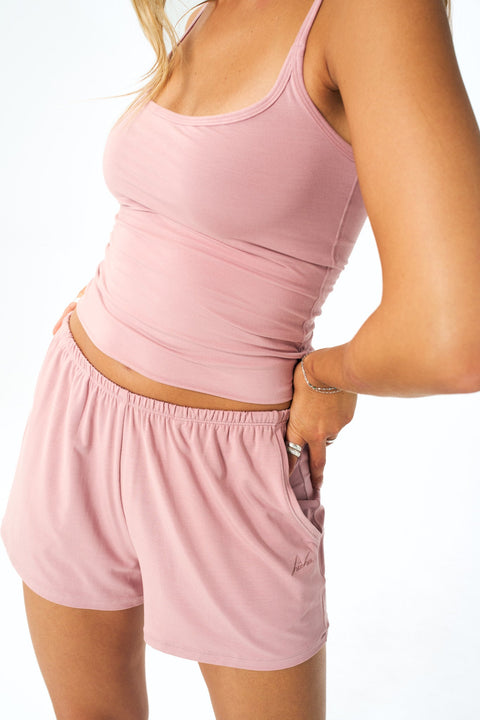 model wearing a soft pink tank top with matching bottoms